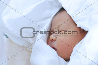 Newborn baby covered in sheet