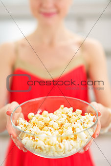 Closeup on young woman giving popcorn