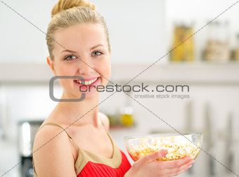 Portrait of happy young woman with popcorn