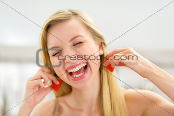 Portrait of happy young woman using strawberry as earring