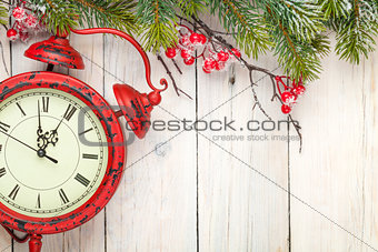 Christmas wooden background with fir tree and antique alarm cloc