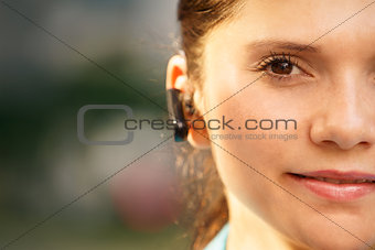 Business woman with phone bluetooth headset smiling