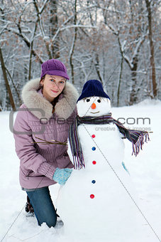 Beautiful girl near a snowman