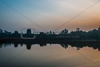 tourist entering Angkor Wat panorama across the moat Cambodia