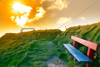 bench on a cliff edge with sunset