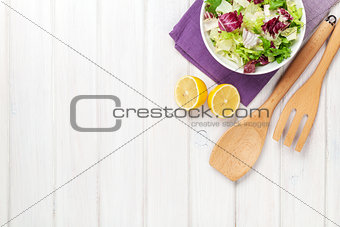 Fresh healthy salad and kitchen utensils