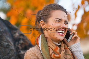 Portrait of happy young woman in autumn outdoors in evening talk