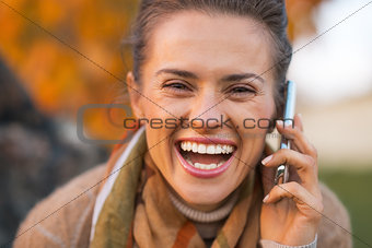 Portrait of smiling young woman in autumn outdoors in evening ta