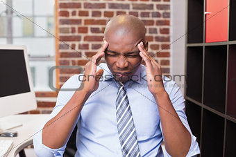 Businessman with severe headache in office