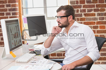 Concentrated male photo editor using computer in office