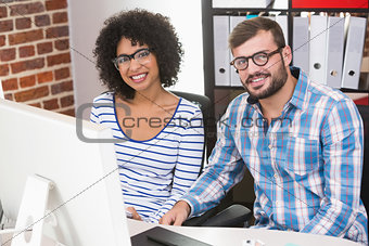 Smiling photo editors at office desk