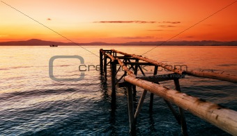 Primitive wooden pier at sunset