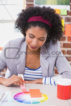 Female designer with color samples at desk