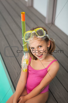 Cute little girl sitting poolside