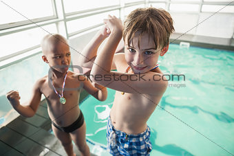 Little boys standing by the pool with medals