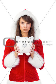 Sad festive woman holding a piggy bank in her hands