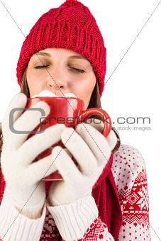 Brunette with winter clothes on holding mug of coffee