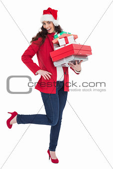 Excited brunette in red coat holding many gifts