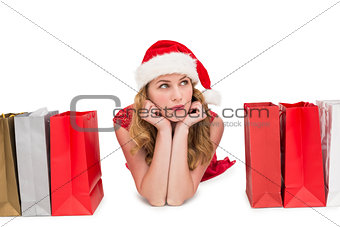 Thoughtful woman lying between shopping bags