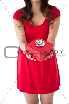 Festive brunette holding red gift