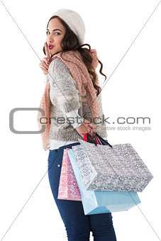 Brunette keeping a secret and holding shopping bags