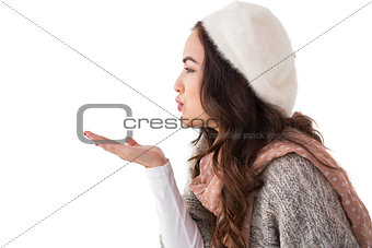 Brunette in winter clothes blowing kiss