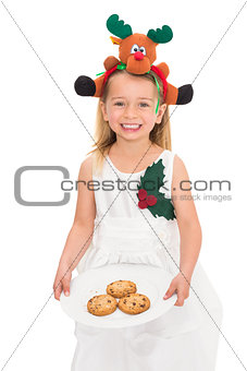Festive little girl holding fresh cookies