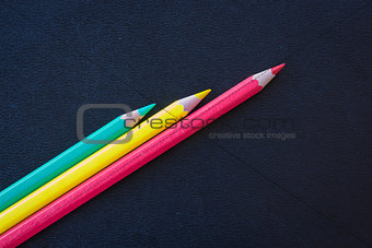 Different color pencils sharpened on dark background