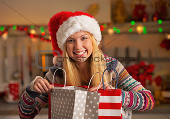 Portrait of happy teenager girl in santa hat with shopping bags