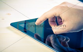 male hands using tablet pc on wood table