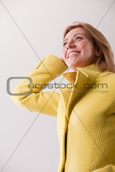 happy mature blonde woman in yellow coat