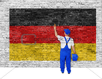 Painter covers brick wall with flag of Germany