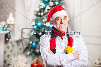 Senior man in Santa's hat on Christmas background