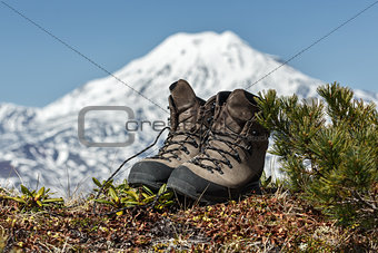 Trekking boots on background volcano