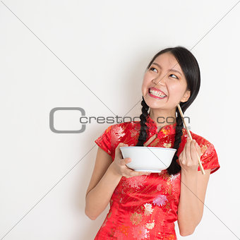 Asian chinese girl eating and looking up