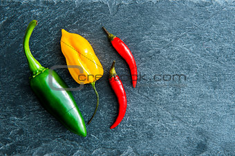 Closeup on mix of chili peppers on stone substrate