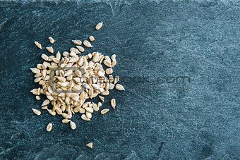 Closeup on peeled sunflower seeds on stone substrate