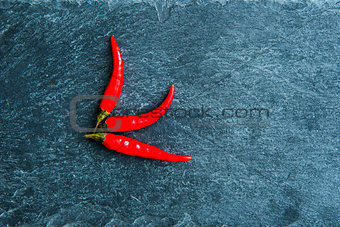 Closeup on red chili peppers on stone substrate