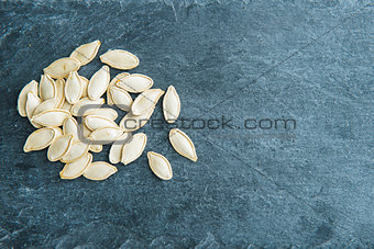 Closeup on pumpkin seeds on stone substrate