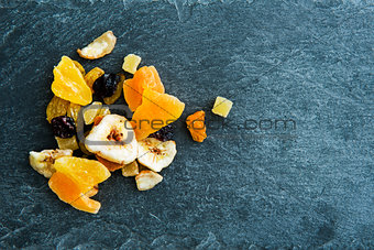 Closeup on mix of dried fruits on stone substrate