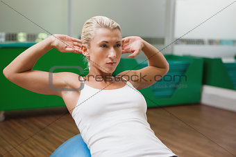 Beautiful woman doing abdominal crunches on fitness ball
