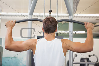 Fit man using weights machine for arms