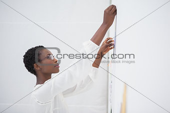Businesswoman with glasses pinning paper up