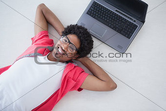 Happy businessman lying near his laptop