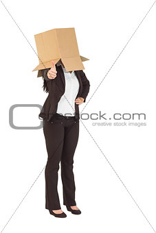 Businesswoman showing thumbs up with box over head