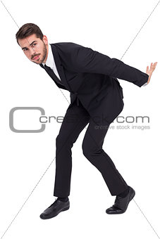 Businessman carrying something with his back and hands