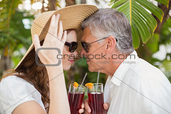 Holidaying couple toasting with cocktails