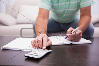 Man working out his finances on the couch