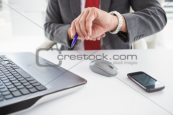 Mature businessman checking the time