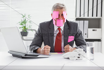 Overwhelmed businessman with sticky notes on head